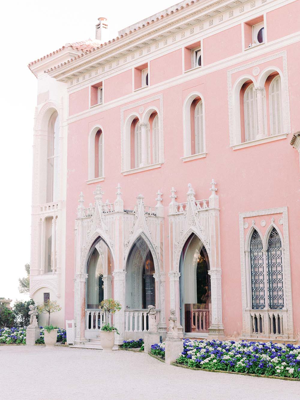 Pink façade of Villa Ephrussi de Rothschild seen from the surrounding gardens